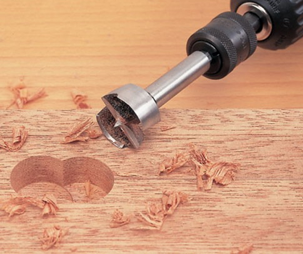 You can drill holes in knots with no problems with round drill bits that are guided by their edges not their tips 