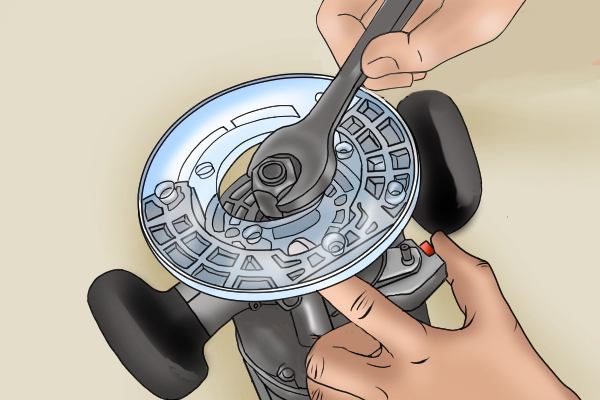 DIYer tightening the spindle lock on a router bit with a spanner