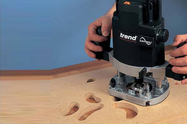Engraving wood with a hand held woodworking router - a power tool for shaping and cutting timber