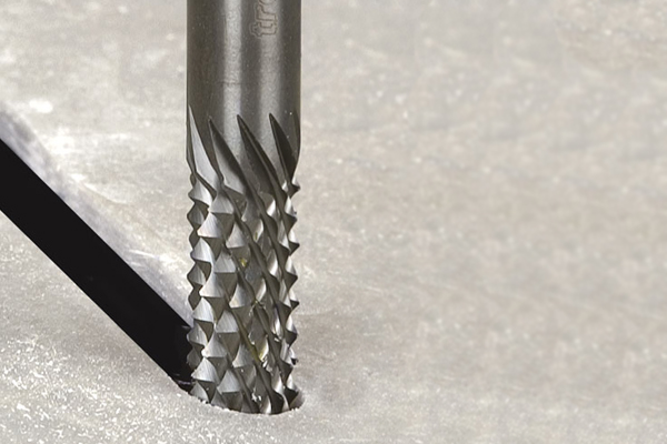 A solid tungsten carbide rasp in use on glass reinforced plastic