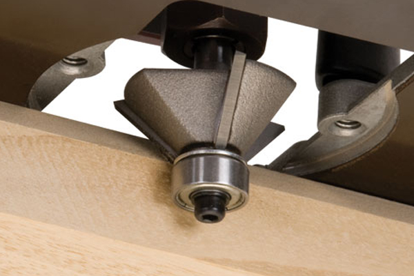 A chamfer router cutter removing the corner from a wooden workpiece