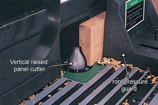 Supporting a workpiece against a false face on the back fence of a router table while using a vertical raised panel router cutter