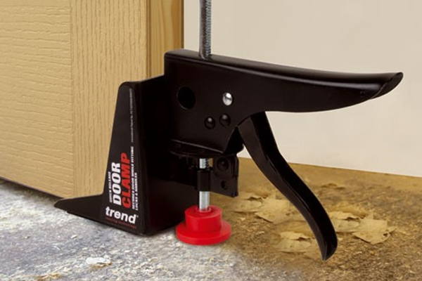 Ratcheted clamp for holding doors in place while they are drilled or planed 